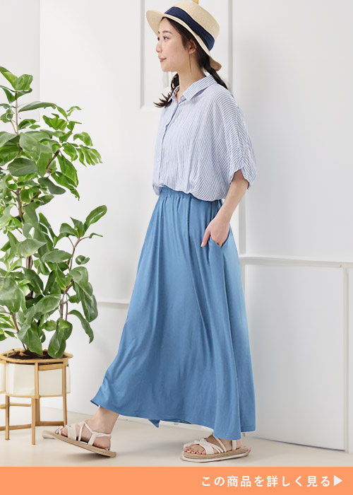 ストライプ柄シャツ×水色のロングスカートを着る女性