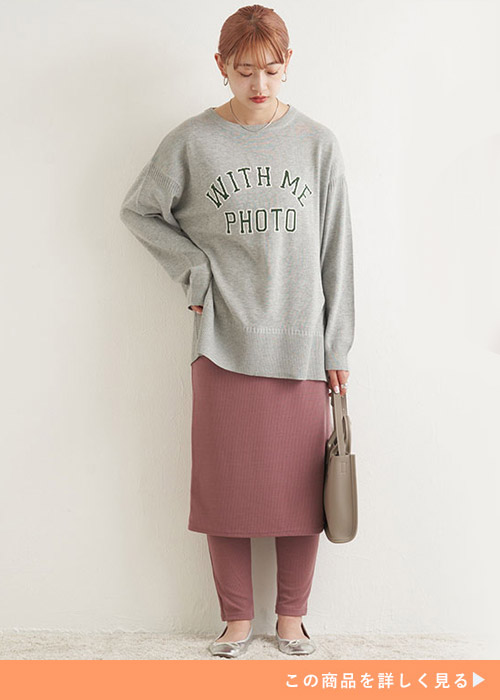 グレーのオーバーサイズトップスを着て、パープルのレギンス×タイトスカートをはく女性