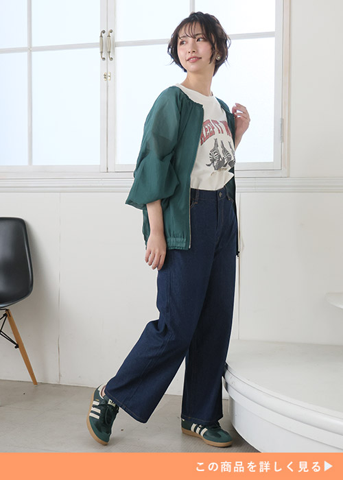 白T×ネイビーのデニムワイドパンツに、グリーンのブルゾンを羽織る女性