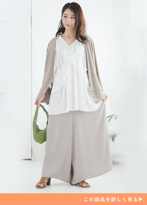 白のフリルブラウス×グレージュのスカンツに、同色系カーディガンを羽織る女性