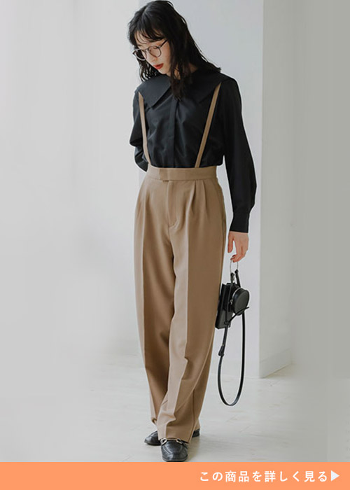 黒のシャツ×ベージュのワイドパンツを着て、黒のローファーを履く女性