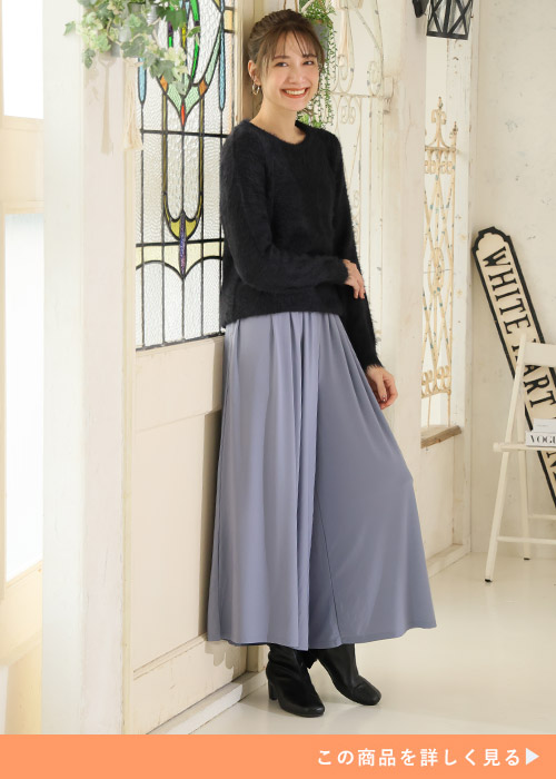 黒のシャギーニット×くすみブルーのフレアーワイドパンツを着る女性