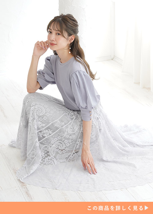 パープルのリブトップスにレースのスカートを履く女性