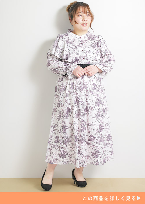 ピンクのウエストリブの花柄ワンピにブラックパンプスを履く女性