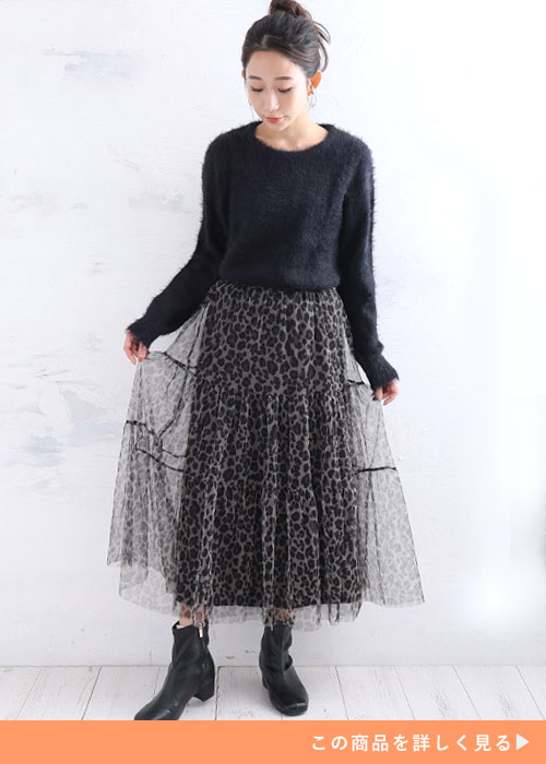 レオパード柄のチュールスカートとブラックニットのコーデにブラックブーツを履く女性