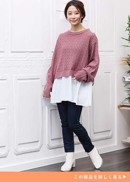 ピンクモカのドッキングニットトップスとスキニーパンツを履く女性