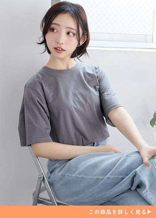 チャコールのTシャツにデニムパンツを履く女性