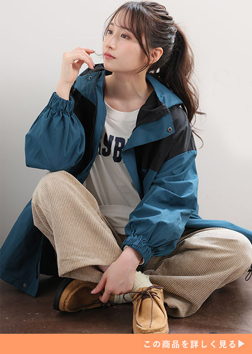 ホワイトTシャツとブラウンパンツのコーデにブルー×ブラックの配色マウンテンパーカを羽織る女性