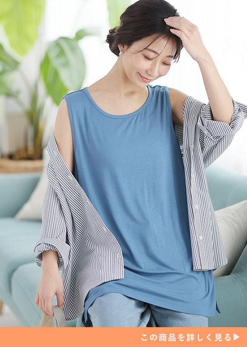 ブルーのタンクトップとデニムパンツのコーデにストライプシャツを羽織る女性