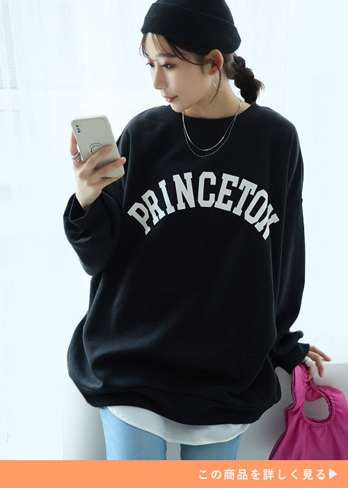 ブルーのパンツに黒のロゴトレーナーを合わせる女性