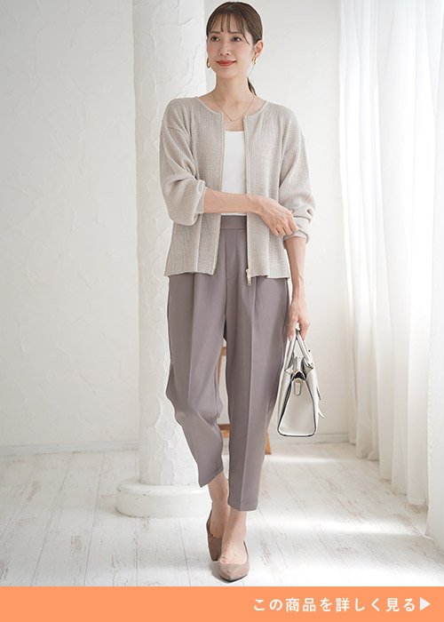 ホワイトインナーとグレイッシュモカのクロップドパンツにベージュのカーディガンを羽織る女性