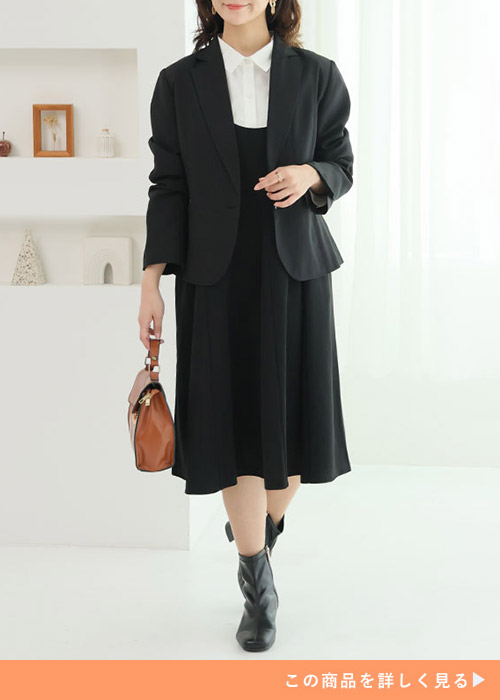 ブラックのフレアワンピースとホワイトシャツのコーデにブラックジャケットを羽織る女性