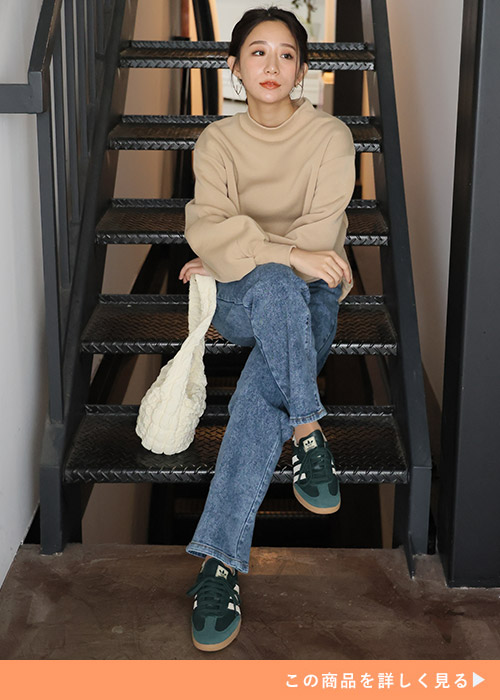 ベージュのスウェット×ストレートデニムパンツを着る女性