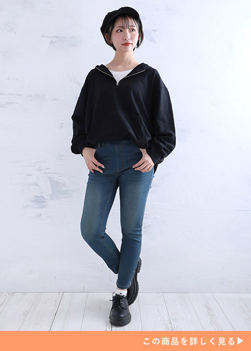 黒のハーフジップスウェット×スキニーデニムパンツを着る女性