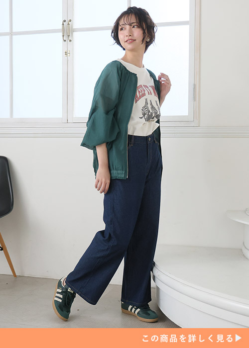 白のプリントTシャツ×ネイビーのワイドデニムに、グリーンのブルゾンを羽織る女性