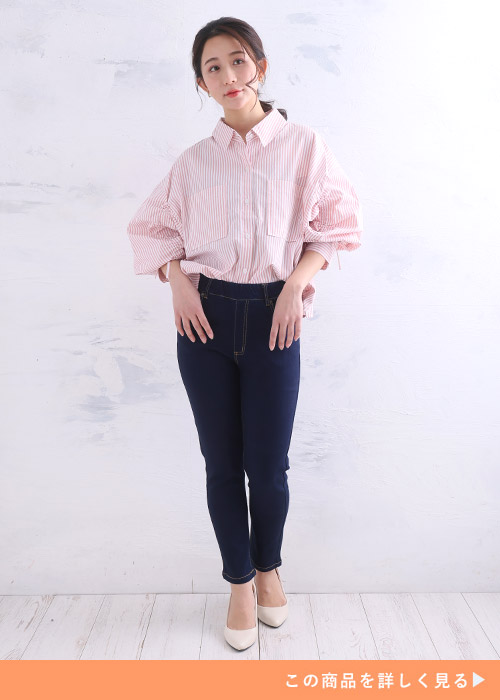 ストライプ柄のデザインブラウス×インディゴのスキニーデニムを着る女性