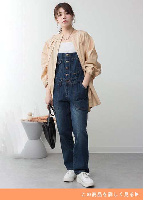 白トップス×デニムサロペットに、くすみピンクのブラウスを羽織る女性