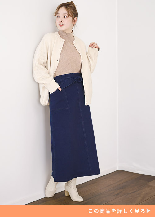 ベージュのニット×アイボリーのカーディガンに、デニムのナロースカートをはく女性