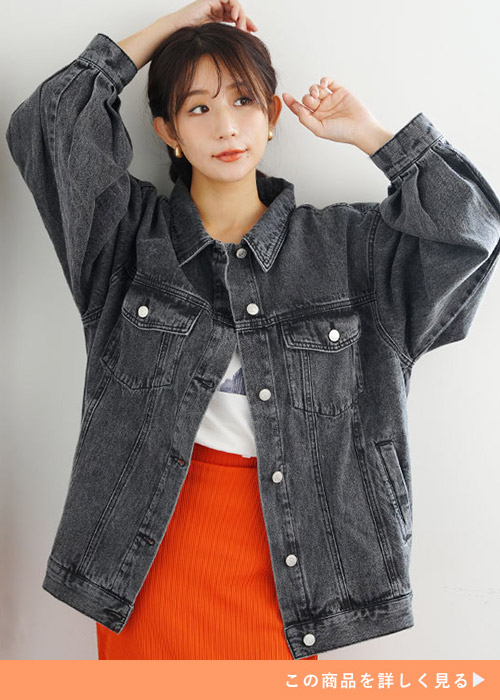 白Tシャツ×オレンジのスカートに、ブラックのデニムジャケットを羽織る女性