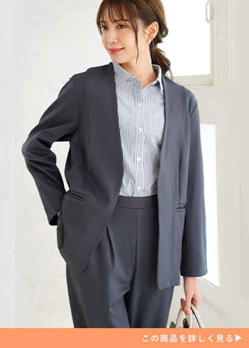 ストライプシャツとグレーのテーパードパンツのコーデにグレーのノーカラージャケットを羽織る女性