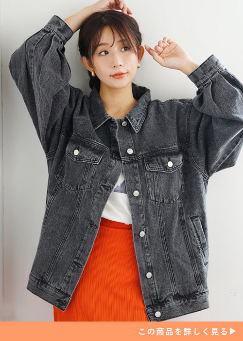 ホワイトトップスとオレンジのスカートにケミカルブラックのジャケットを羽織る女性