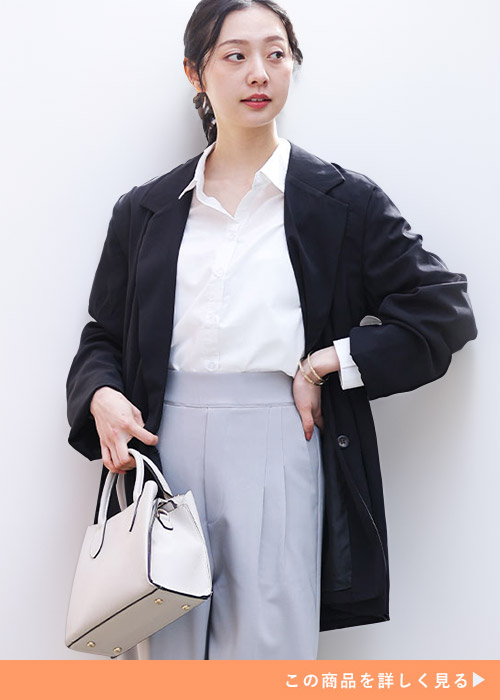 ホワイトシャツとグレーパンツのコーデにブラックのテーラードジャケットを羽織る女性