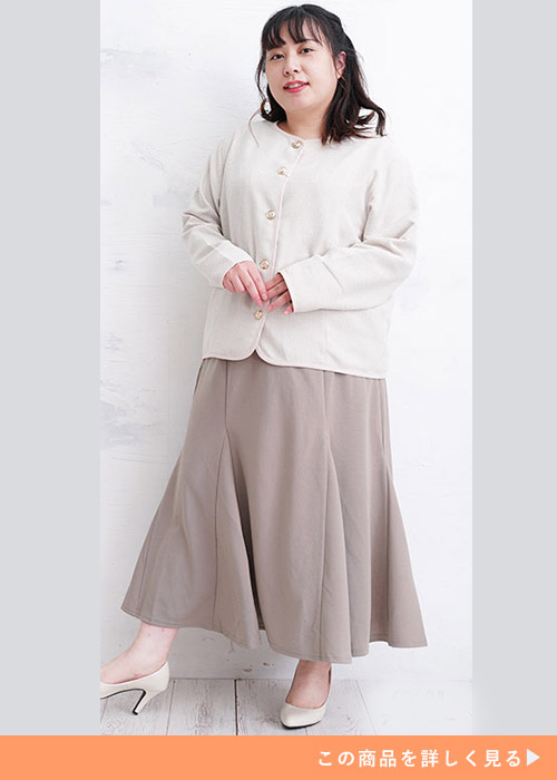 アイボリーのノーカラージャケットとブラウンのフレアスカートのコーデにパンプスを履く女性