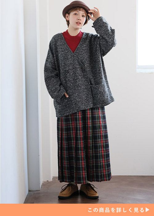 ワインレッドのトップスとチェックスカートのコーデにチャコールのカーディガンを羽織る女性