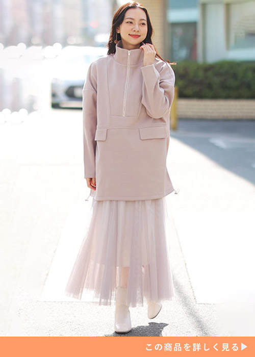 グレージュのスタンドカラーパーカとチュールスカートのコーデにホワイトブーツを履く女性