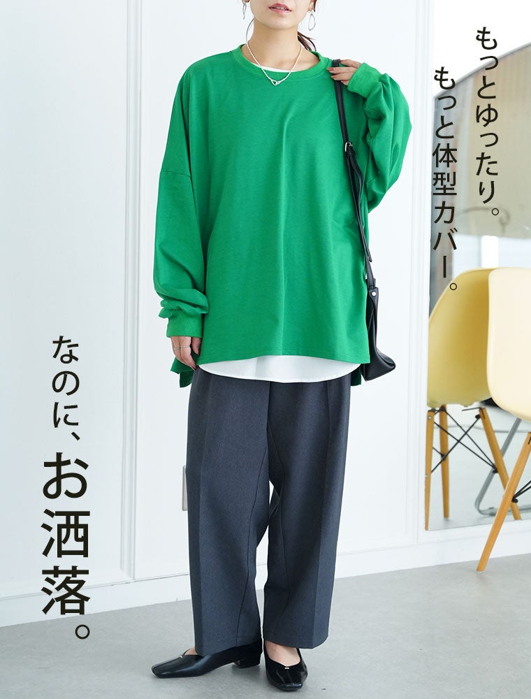 白Tシャツ×グリーンのトップスを着て、テーパードパンツを履く女性