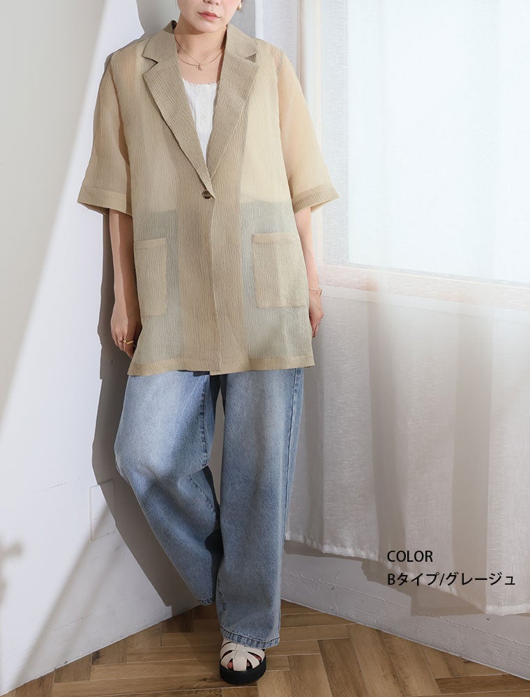 グレージュのシアージャケットを着て、デニムを履く女性。