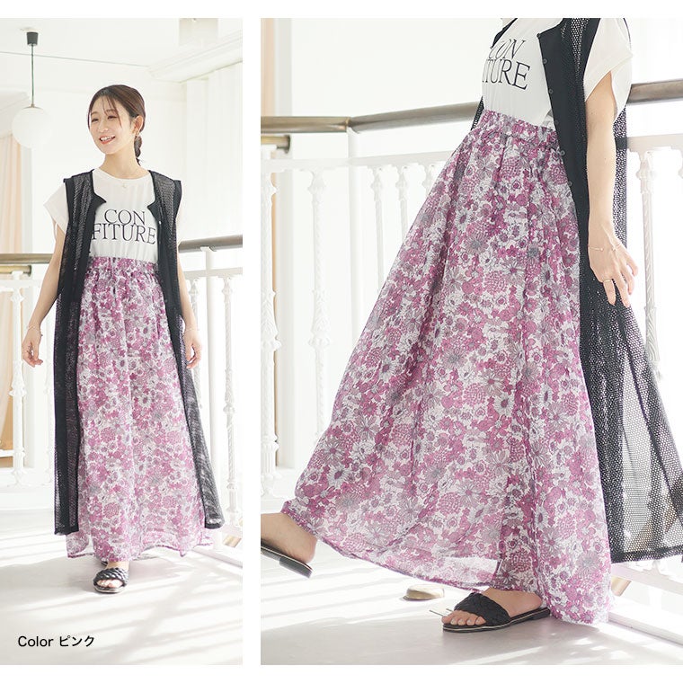 Tシャツ×シアー素材ジレを着て、花柄のAラインスカートを履く女性
