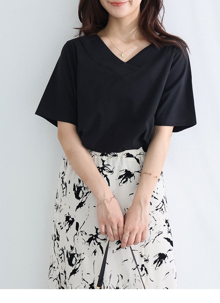 ブラックのVネックTシャツと花柄のスカート