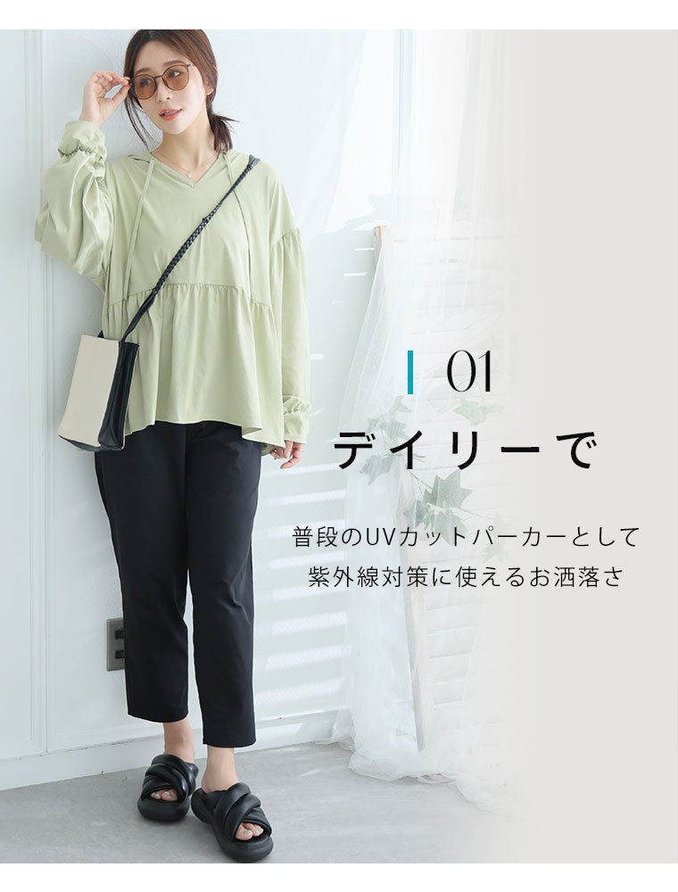 黒いパンツにグリーンのUVケアパーカを羽織る女性