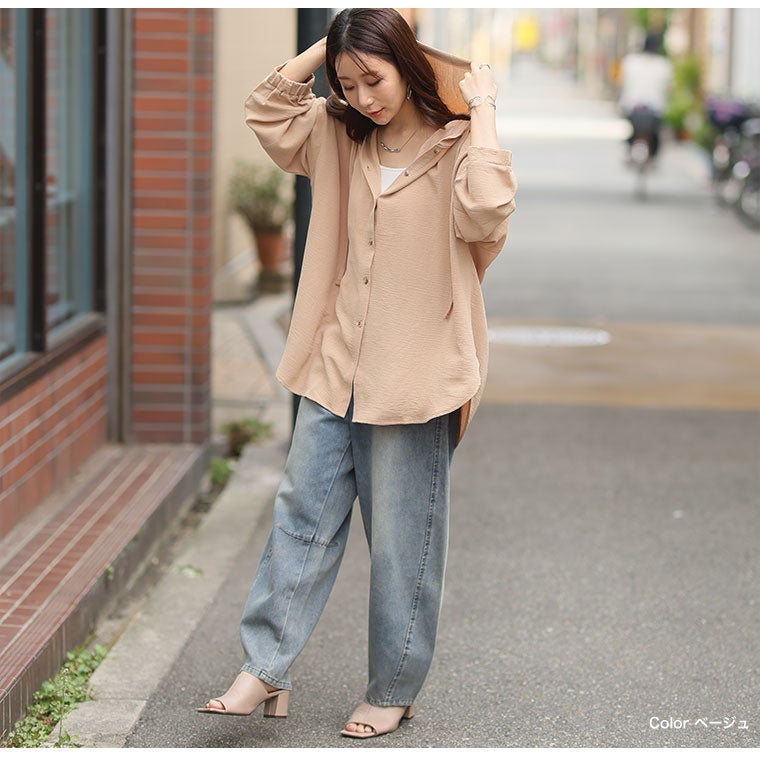 モカのシアートップスを着て、デニムパンツを履く女性