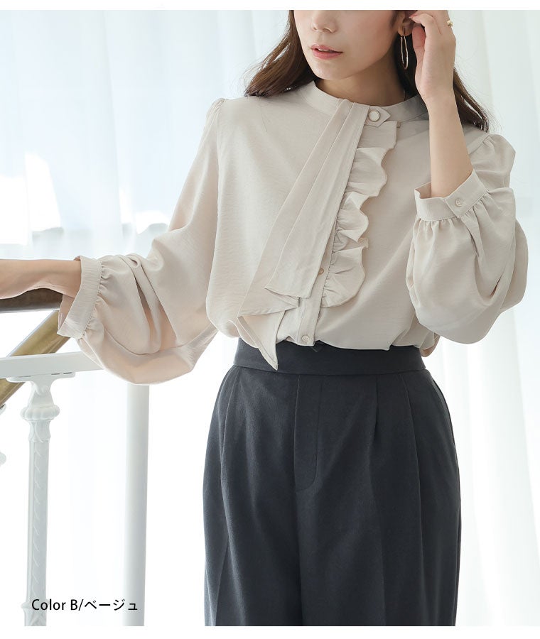 ベージュのフリルブラウスに黒のボトムを合わせる女性