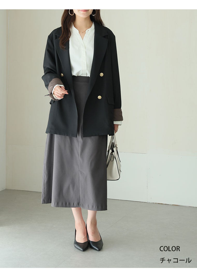 白トップス×黒ジャケット×チャコールのタイトスカートを着て、黒のジャケットを羽織る女性